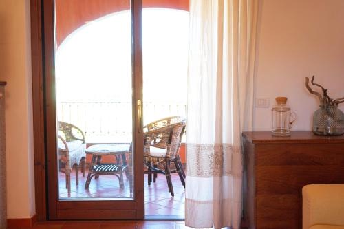 维拉西米乌斯Mereu Central Apartment的一间设有一扇门的客房,可通往带桌子的阳台