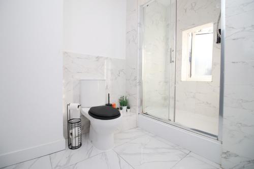 布里真德Executive Style 2 Bed Flat in Bridgend F2的白色的浴室设有黑色座椅和卫生间