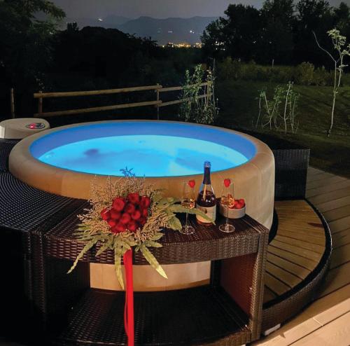GhiaieNatur Air Suite的热水浴池、桌子和一瓶葡萄酒