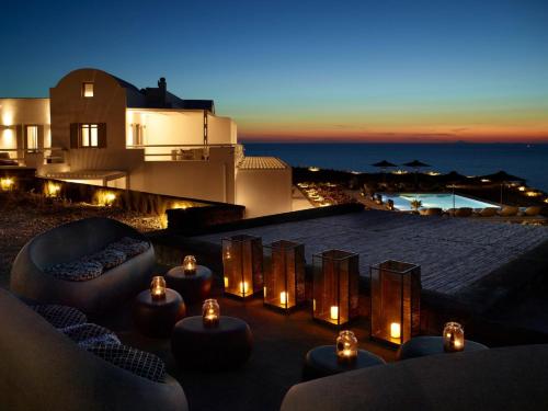 阿克罗蒂里Absolute Paradise Santorini的屋顶庭院在晚上提供蜡烛和沙发