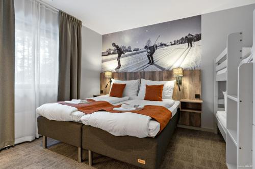 莫拉First Camp Moraparken Hotel的卧室配有一张大床,墙上挂有绘画作品