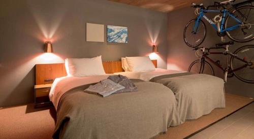 尾道市塞克尔酒店的卧室配有两张床,墙上挂着自行车