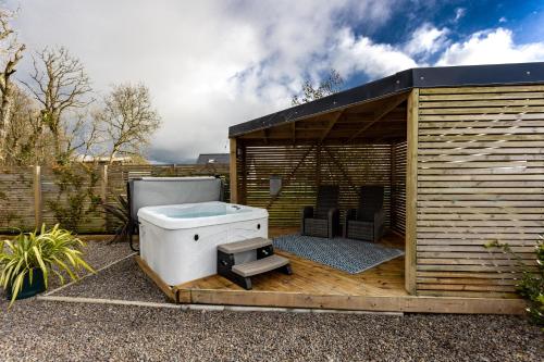 滕比The Lodge @Quarrywood的木制甲板上的热水浴池和烧烤架