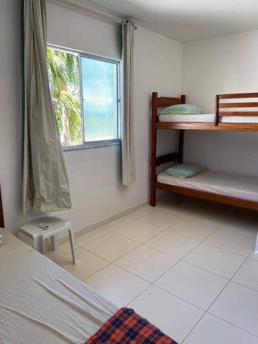 伊塔帕里卡岛维拉克鲁兹apartamento de frente para o mar的一间卧室配有双层床和窗户。