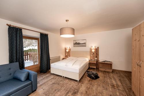 修希Hotel Profanter的一间卧室配有一张床、一张沙发和一个窗口