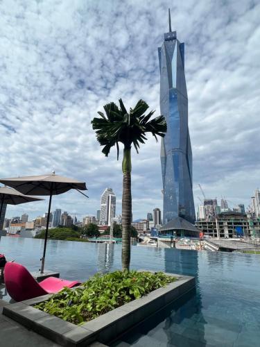 吉隆坡Opus Residences KL Malaysia的棕榈树和高楼中的游泳池