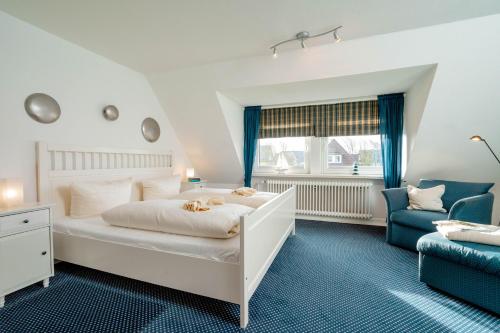 文尼斯塔特Haushälfte Stranddiestel的卧室配有白色的床和蓝色椅子