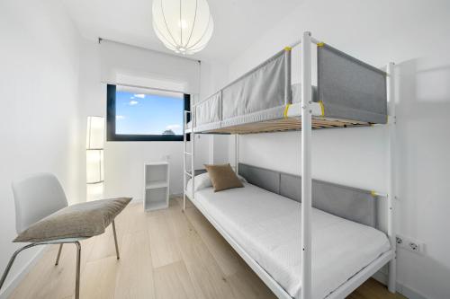 拉梅特拉·德·玛尔Gregal by enjoy Rocas Doradas的一间小卧室,配有双层床和椅子