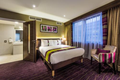 沃特福德伦敦沃特福德枢纽假日酒店的配有一张床和一把椅子的酒店客房