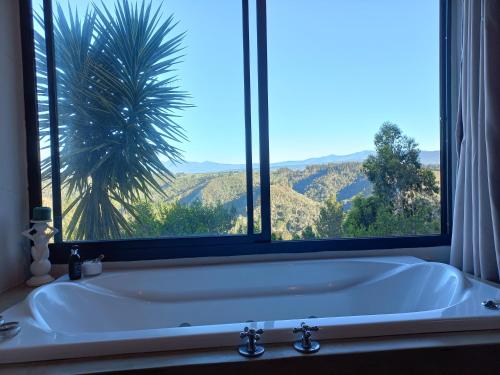 克尼斯纳Forest Valley Cottages的带浴缸的浴室和窗户
