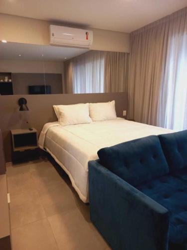 圣保罗Cityhome Platina Tatuapé的一间卧室配有一张大床和一张蓝色的沙发