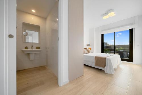 拉梅特拉·德·玛尔Garbí by enjoy Rocas Doradas的白色卧室设有床铺和水槽