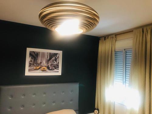 科尔多瓦NUEVOCENTRO 1的一间卧室配有一张床和天花板灯