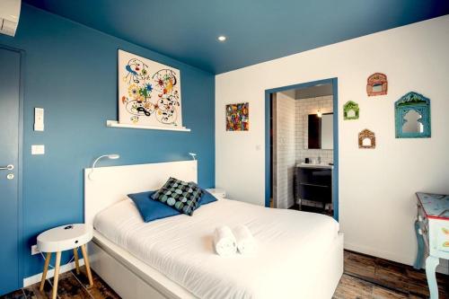 拉卡诺La COLOC的卧室拥有蓝色的墙壁和白色的床。