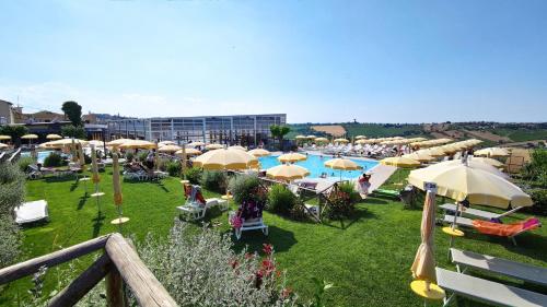 圣马赛罗莫罗贝洛酒店的享有带遮阳伞和椅子的游泳池的景色