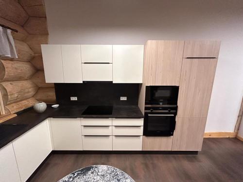 韦尔本Ferienhof Weisser Hirsch的厨房配有白色橱柜和黑烤箱。
