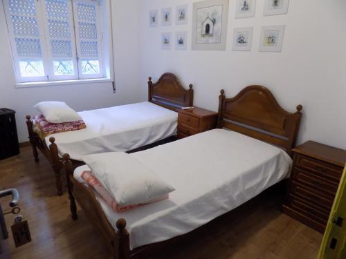 卡米尼亚Albergue de São Bento的一间卧室设有两张床和窗户。