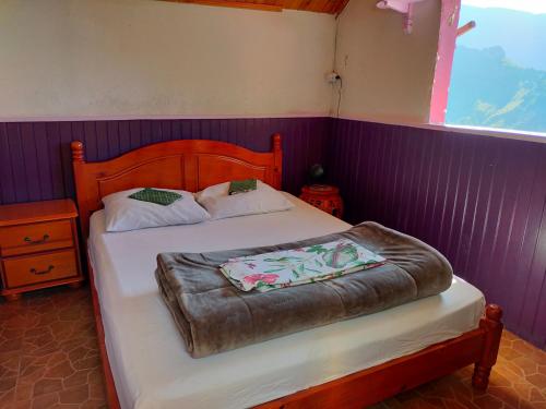 锡拉奥KER L'ÎLET的一间卧室配有一张带木制床头板的床