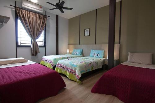 马六甲Harmonia Homestay的一间卧室配有两张床和吊扇