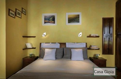 皮恩扎PienzaLettings "Casa Gioia"的一间卧室设有一张黄色墙壁的大床