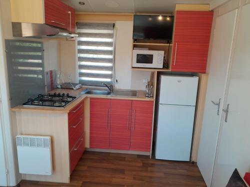 加的斯La Muela的一间小厨房,配有红色橱柜和白色冰箱