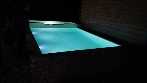 KljučBungalovi Ključ的暗室里的一个蓝色灯光游泳池