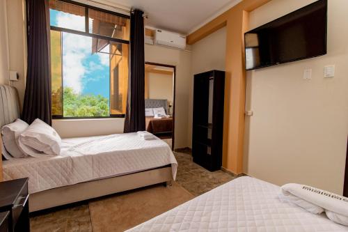 塔拉波托Sonqu Tarapoto的一间卧室设有两张床和大窗户
