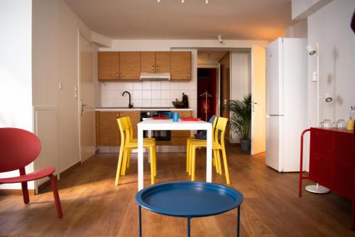 帕特雷RYB Colour Apartment的厨房配有桌子和一些黄色的椅子
