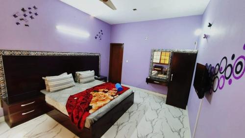 卡拉奇Best Couple Coprtive Guest House的紫色客房内的一间卧室,配有一张床
