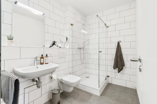 登茨林根Empire Living: Denzlingen Marktplatz的白色的浴室设有卫生间和水槽。