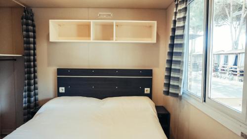 阿梅利亚Chalet Grand Charme voor 4 personen op Camping River Village - JoyCasa的一间小卧室,配有床和窗户