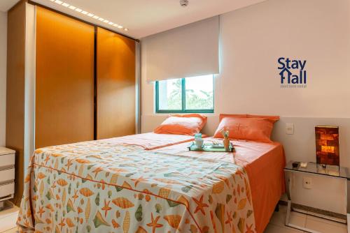 伊波茹卡Apt Marulhos-Beira Mar-Melhor praia de Muro Alto-058M的一间卧室配有一张带橙色床罩的床
