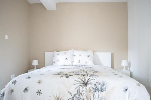 安特卫普NSD Home的卧室配有白色床和花卉床罩