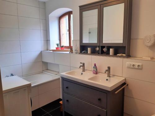 厄斯特里希-温克尔Rheingauzeit的浴室设有2个水槽、镜子和浴缸。