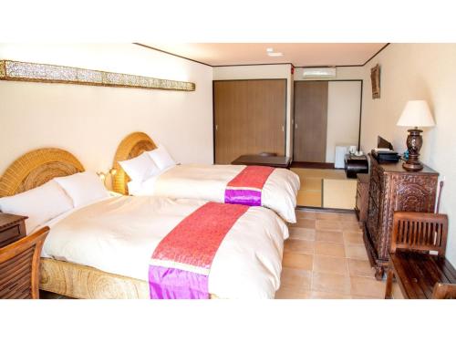 MitsuneHachijojima Hotel Resort Sea Pillows - Vacation STAY 53191v的酒店客房配有两张床和一张书桌