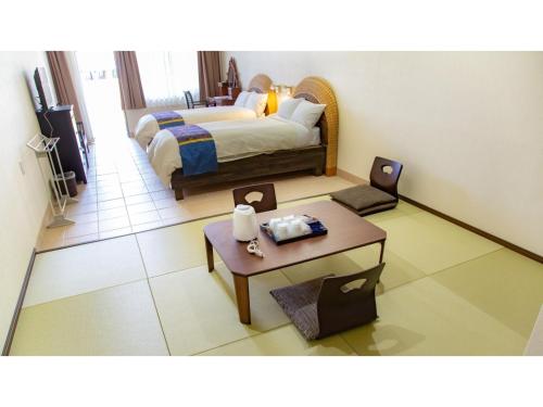MitsuneHachijojima Hotel Resort Sea Pillows - Vacation STAY 53316v的酒店客房配有一张床铺和一张桌子。