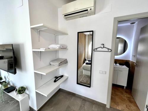 特拉萨Loft moderno en buena ubicación的一间设有白色架子和镜子的房间