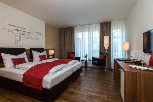 圣马丁Weingut Schreieck VINOTEL & GUTSHAUS的酒店客房设有一张大床和一张书桌。
