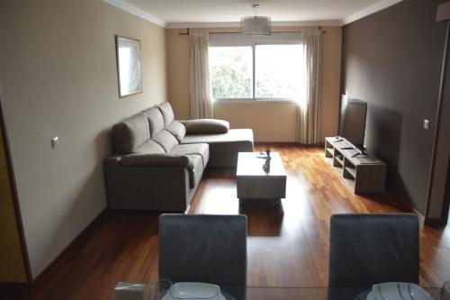 大加那利岛拉斯帕尔马斯Apartamento complejo residencial的带沙发和电视的客厅