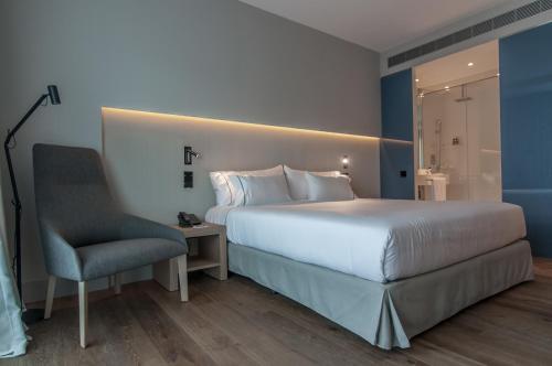 Vilassar de Dalt苏丽埃莫绅酒店的一间卧室配有一张大床和一把椅子