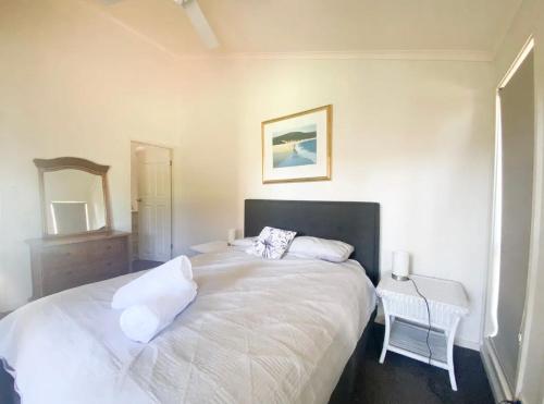 尼尔森湾Coconuts - 3 bedroom 3 bathroom townhouse with tennis court的卧室配有一张白色大床和镜子