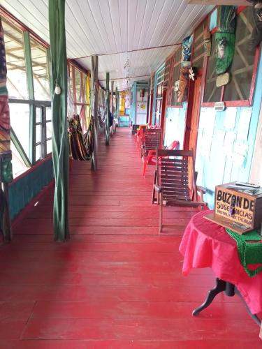 Puerto NariñoHostal tachiwa的一辆火车车,车上铺有红色地板,配有椅子和桌子