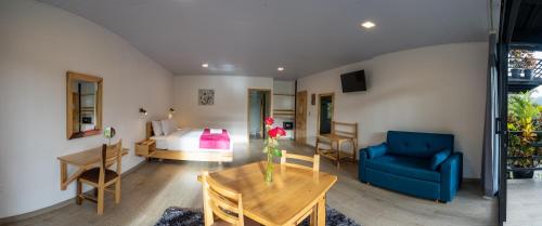 明多Las Terrazas de Dana Boutique Lodge & Spa的一间卧室配有一张床、一张蓝色的沙发和一张桌子