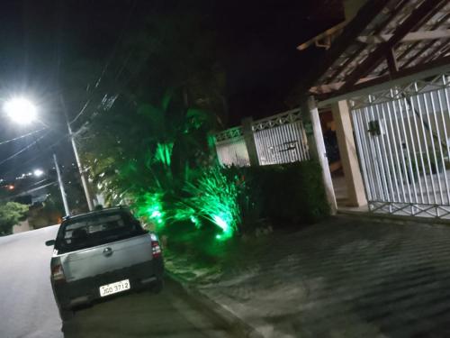 阿蒂巴亚Hospedagem Maria Joana的停在有绿灯的房子前面的汽车