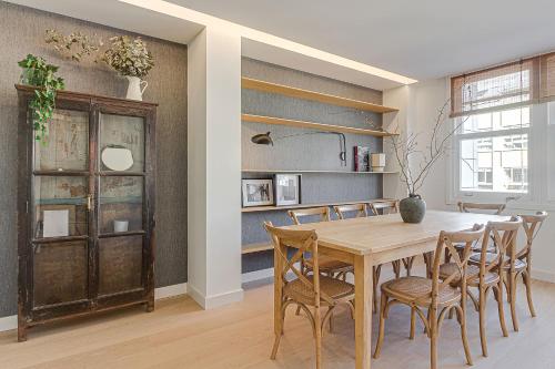 拉科鲁尼亚Riazor Deluxe Penthouse的一间带木桌和椅子的用餐室