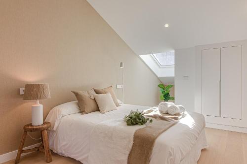 拉科鲁尼亚Riazor Deluxe Penthouse的卧室配有白色的床和窗户