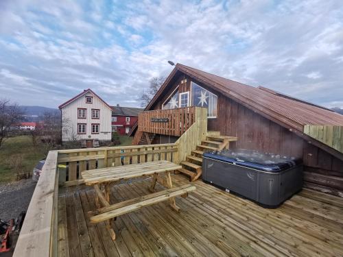 莱旺厄尔Unik fjøsleilighet的木甲板上设有长凳和房子