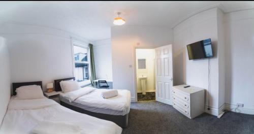 南安普敦Howard House的酒店客房设有两张床和电视。