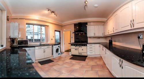 南安普敦Howard House的一间设有白色橱柜和瓷砖地板的大厨房