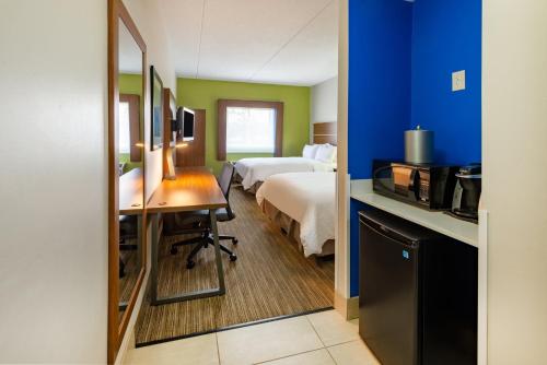 Vermilion克利夫兰智选假日酒店 - 凡米利翁的酒店客房配有一张床、一张书桌和一间厨房。